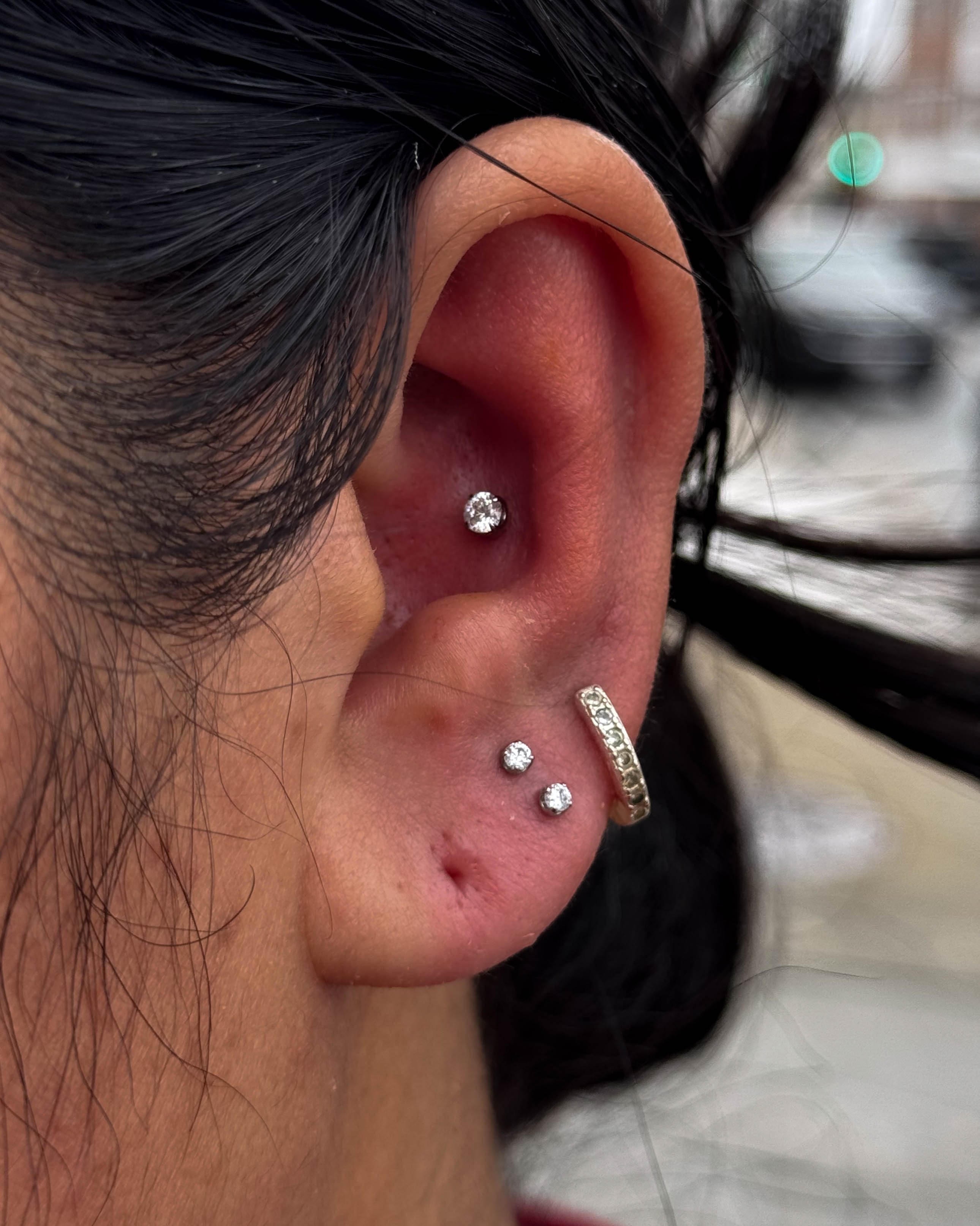 Titanium jewellery piece from Junipurr with CZ prong setting worn in a conch and helix placement