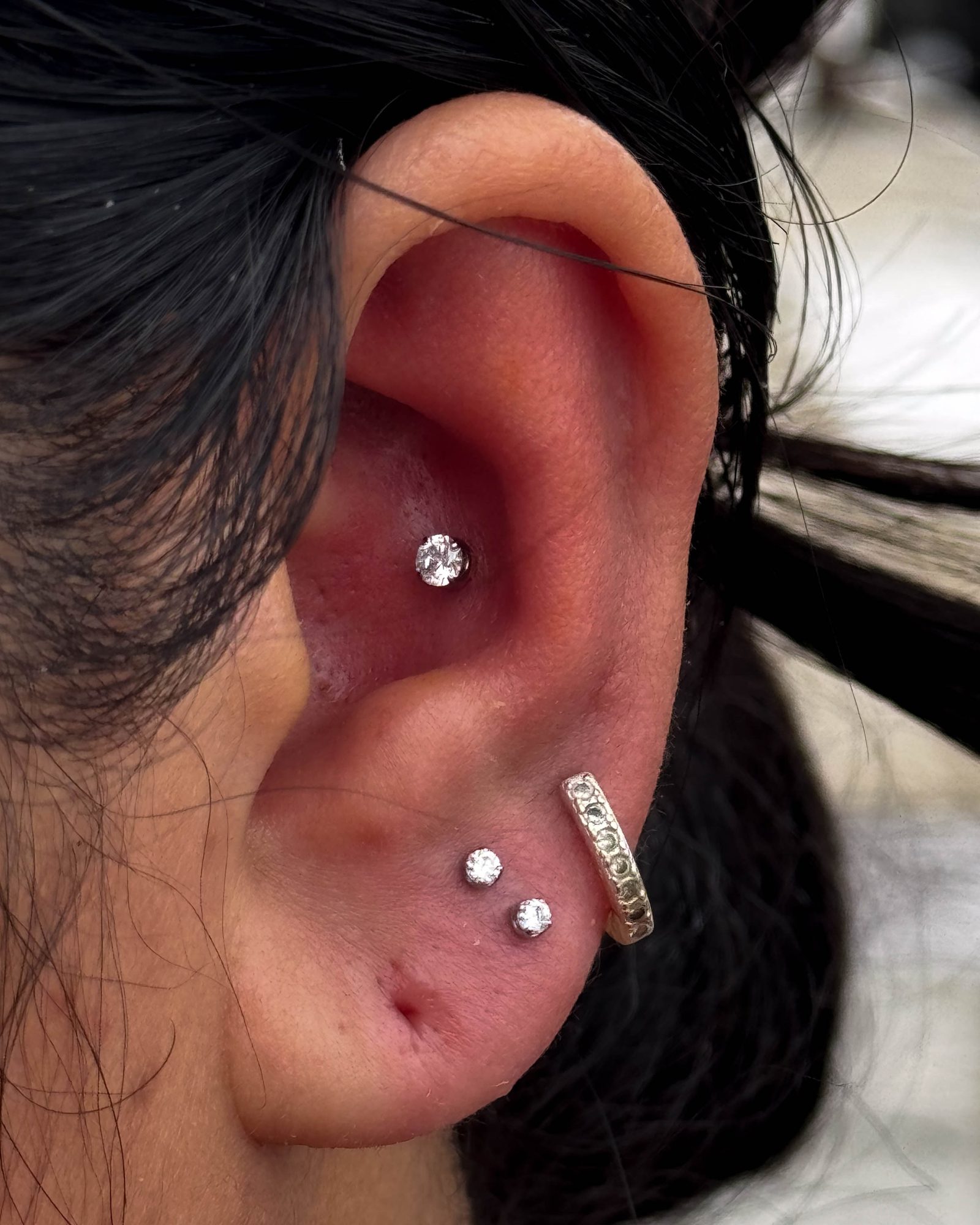Three-piercing ear curation by Stab Daddy Bri